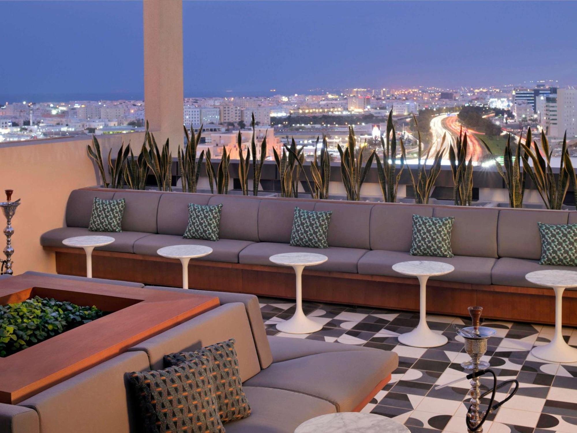 Moevenpick Hotel & Apartments Ghala Mascate Exterior foto The rooftop lounge at the Hotel Indigo